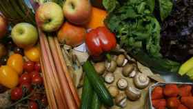 Una cesta de la compra con frutas, verduras y hortalizas.