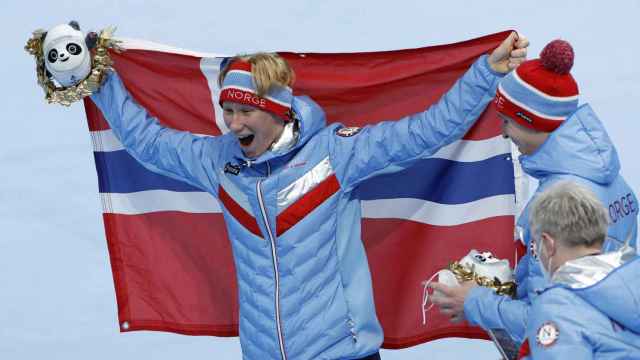 Peder Kongshaug, con la bandera de Noruega después de ganar el oro en la prueba de persecución por equipos de los Juegos Olímpicos de Invierno de Pekín 2022.