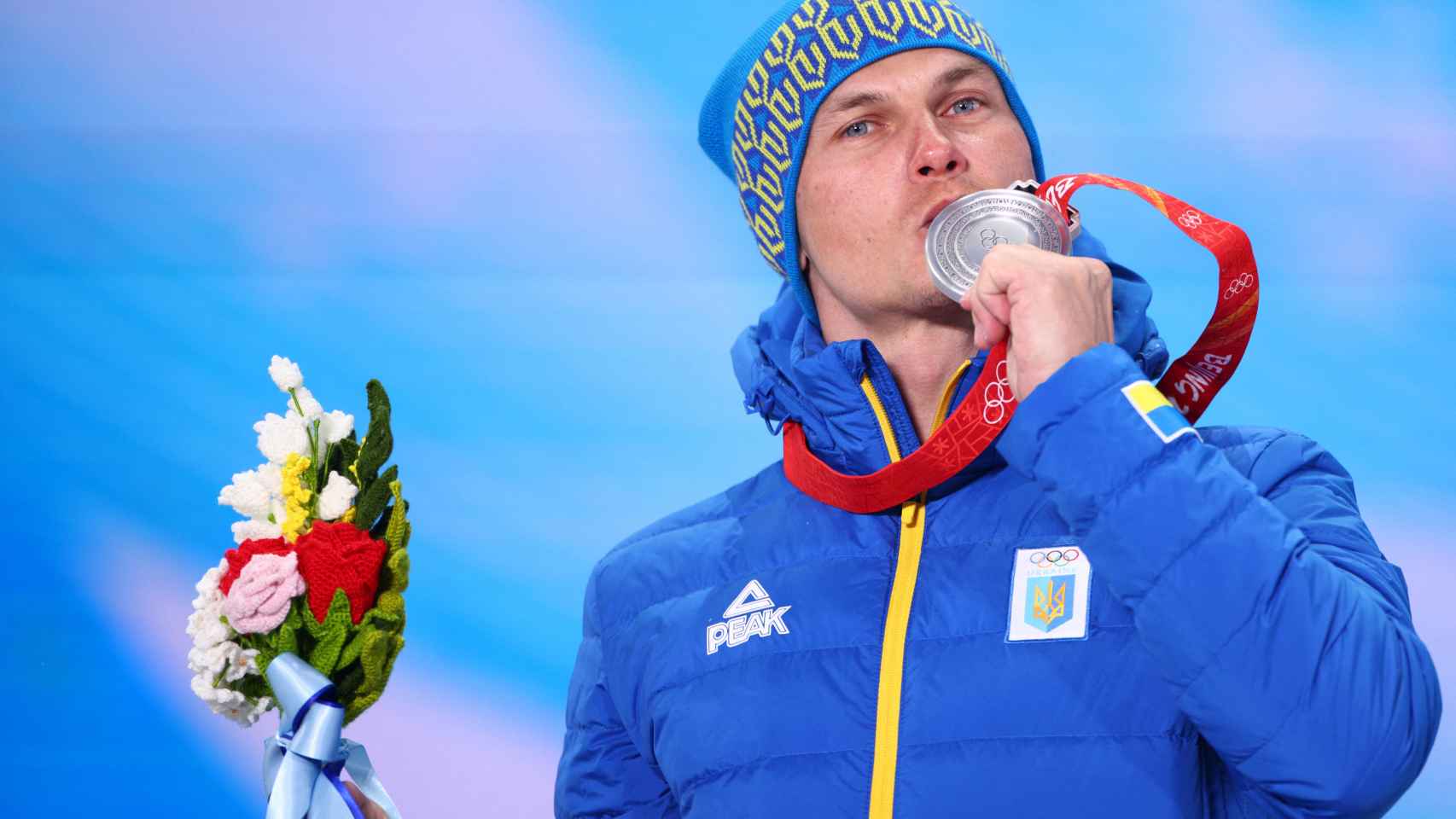 Olexandr Abramenko besando su medalla en Pekin 2022