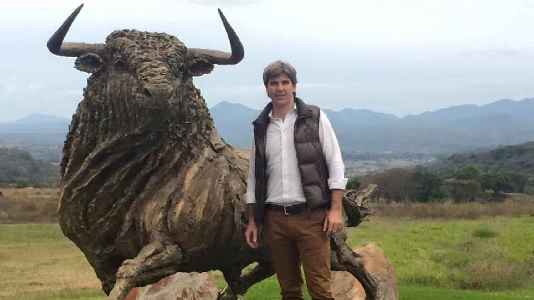 El empresaro Daniel Alcázar posando con la escultura de un toro en el año 2015.