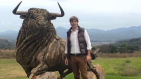 El empresaro Daniel Alcázar posando con la escultura de un toro en el año 2015.