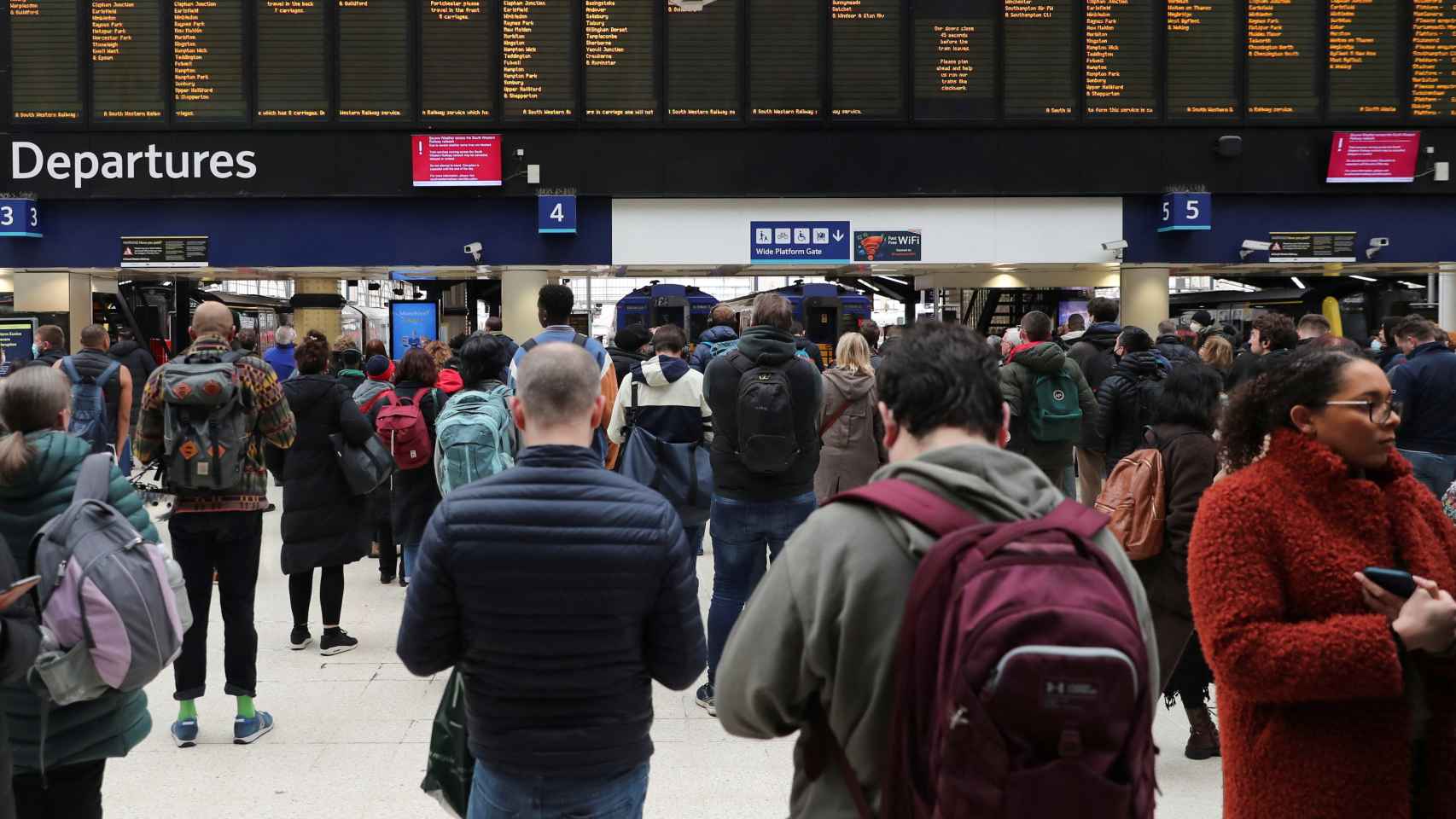 Decenas de personas observan las pantallas de la estación de Londres tras las cancelaciones por la tormenta.