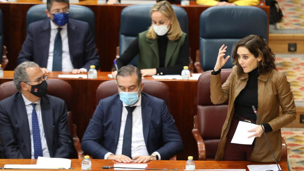 El consejero de Educación, Enrique Ossorio, el consejero de Presidencia, Justicia e Interior, Enrique López, y la presidenta de la Comunidad de Madrid, Isabel Díaz Ayuso, en un pleno de la Asamblea.