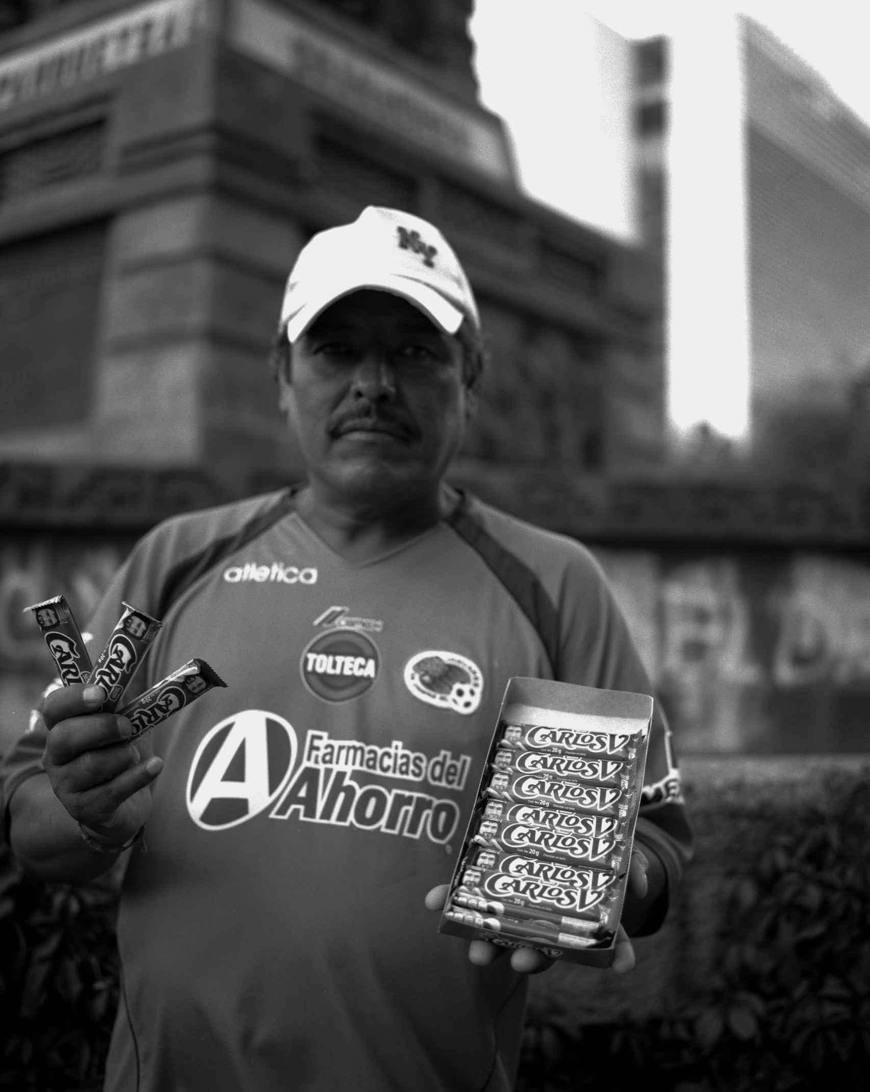 Vendedor ambulante de chocolates Carlos V junto al monumento a Cuauhtémoc, Ciudad de México,  2016