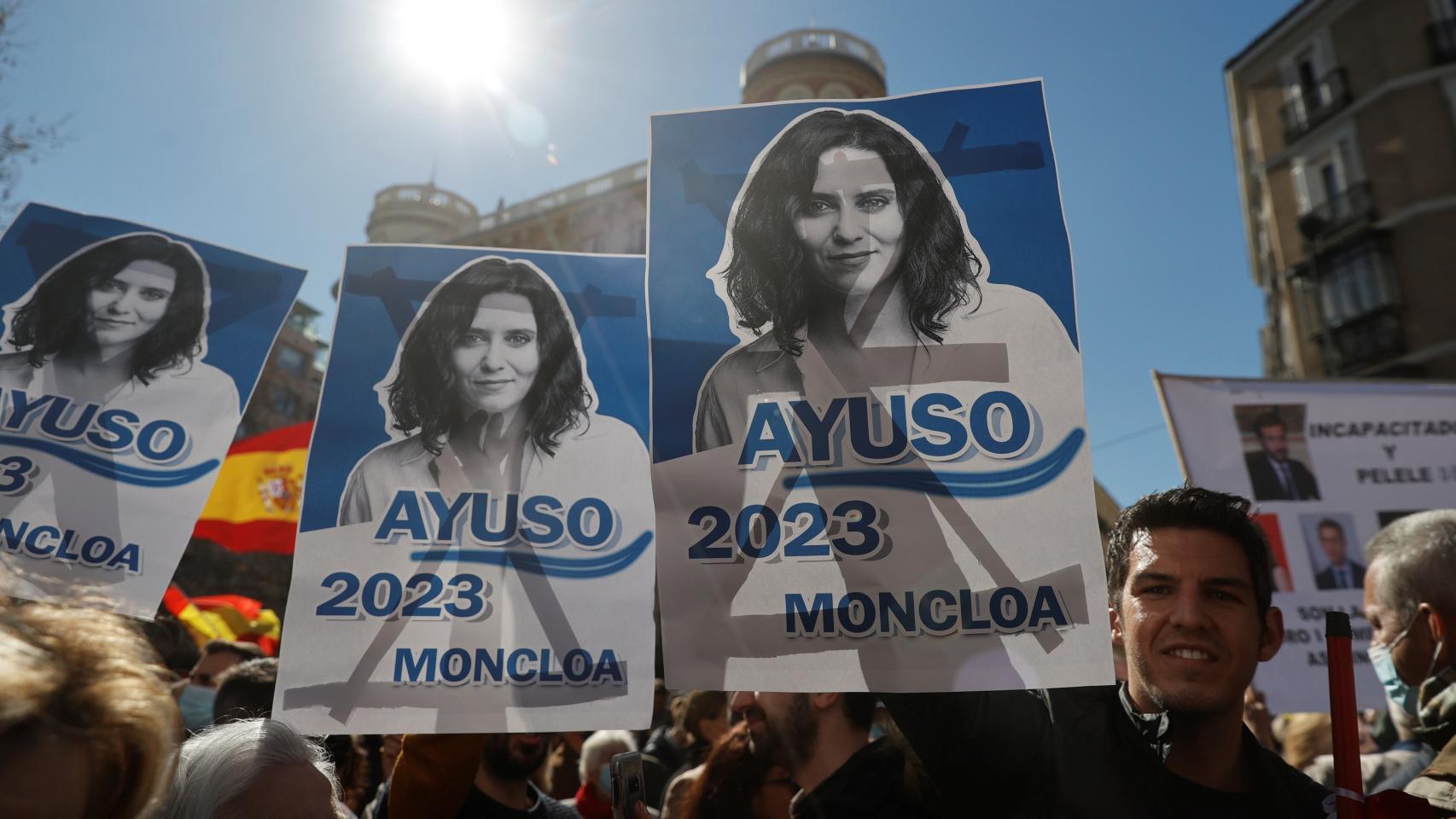 Manifestantes portan carteles pidiendo la candidatura del PP a las generales de 2023 para Isabel Díaz Ayuso.
