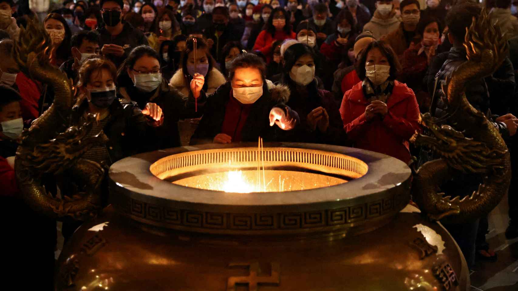 Gente rezando en un templo de Taipei por el Año Nuevo Lunar.