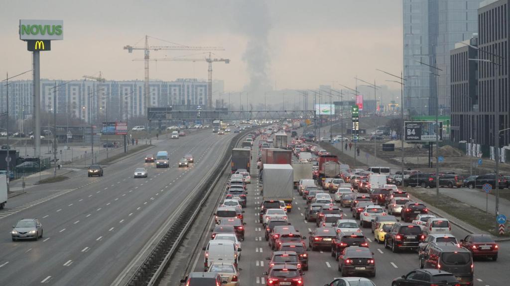 Los habitantes de Kiev intentan huir de la ciudad, con las columnas de humo al fondo.