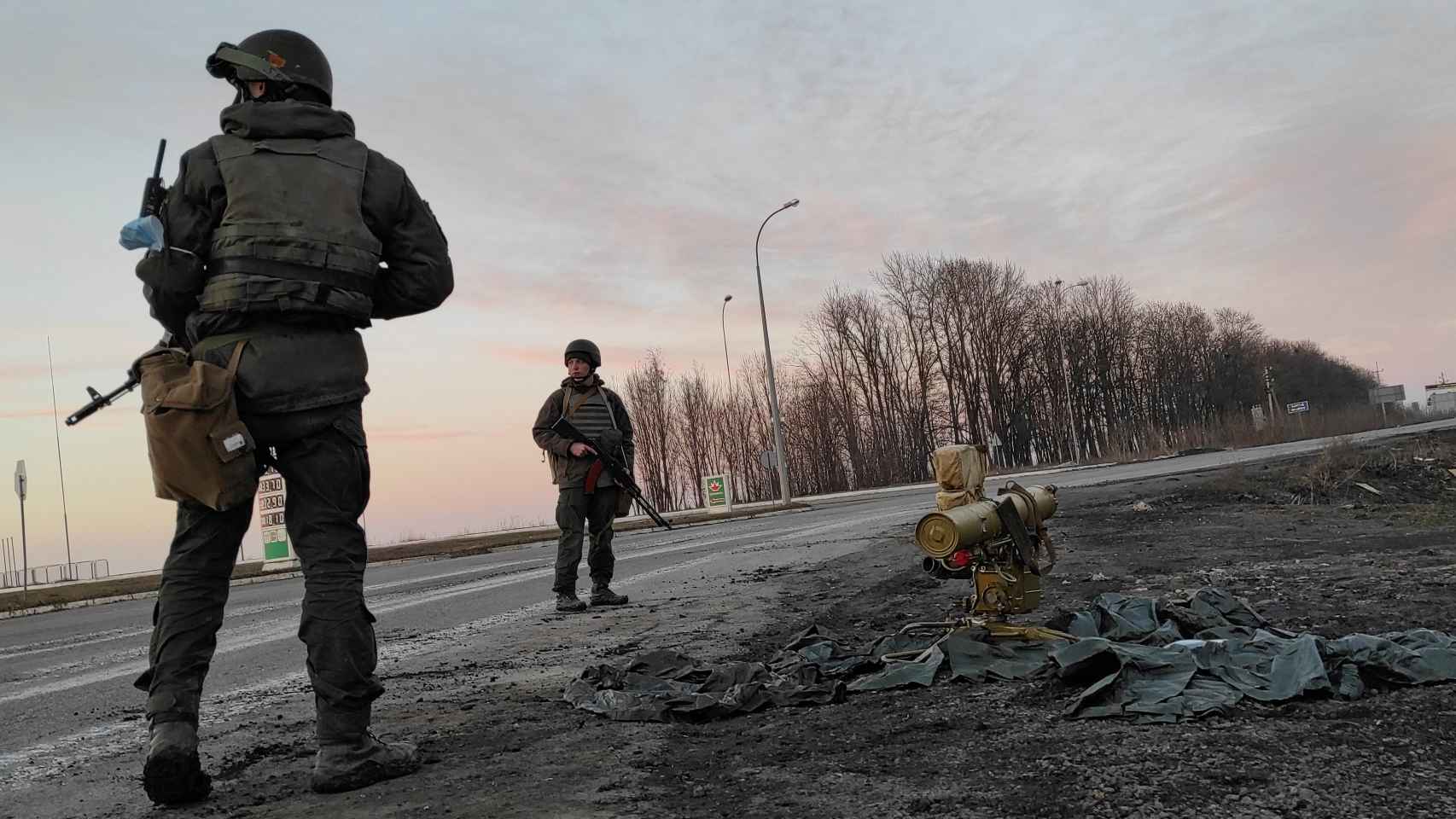 Soldados ucranianos en una carretera en las afueras de Kharkiv, junto a un lanzador de cohetes.