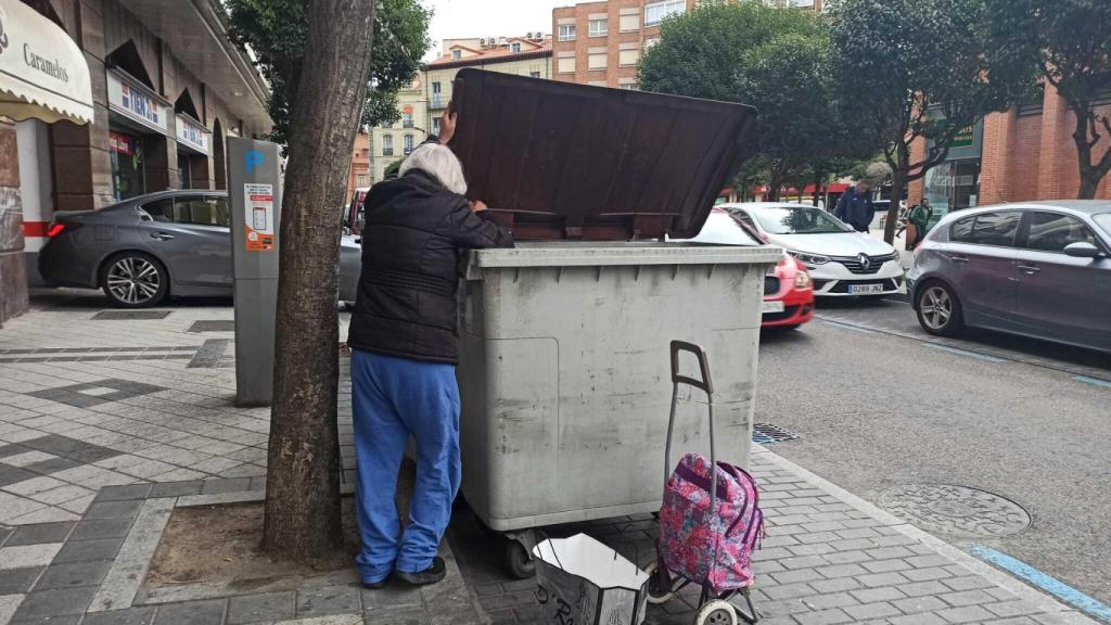 Una mujer busca comida en un contenedor de Valladolid