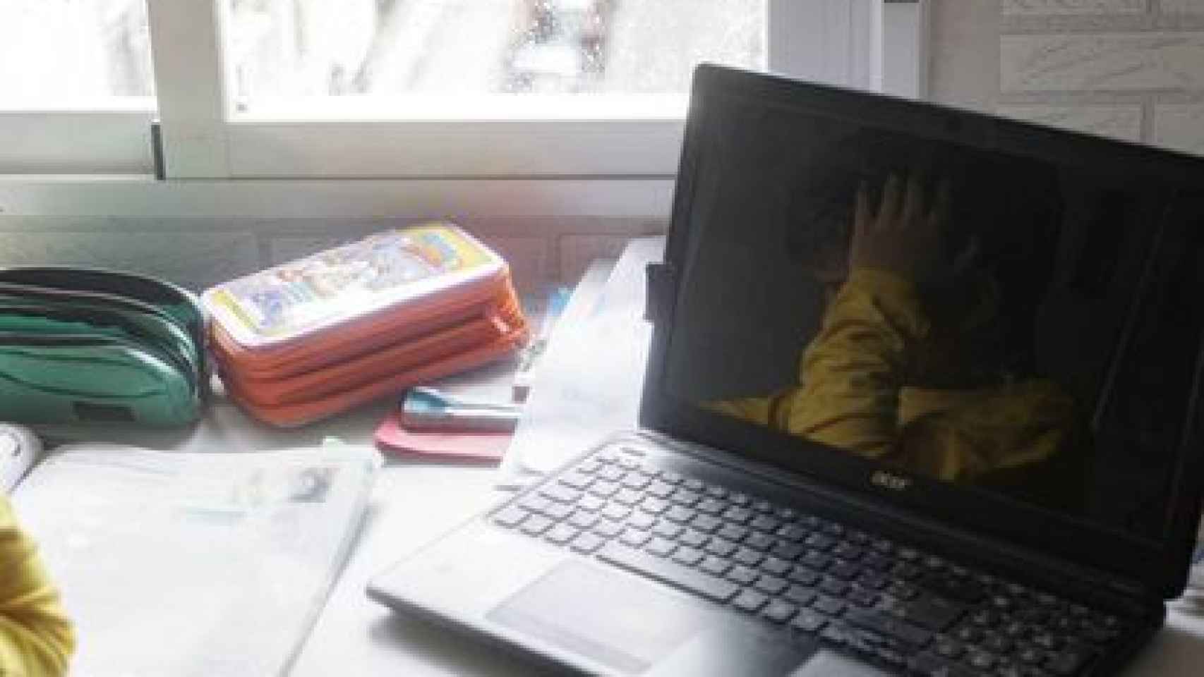 Un niño estudia con un ordenador delante.