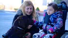 Una niña con una enfermedad rara juega con un perro de terapia.