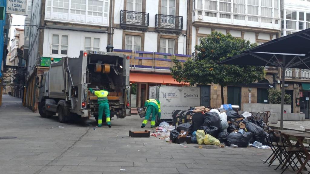 Dos trabajadores recogiendo la basura acumulada en la calle San Nicolás de A Coruña en una foto de archivo.