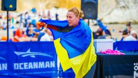 Una mujer envuelta con la bandera de Ucrania en una de las pruebas organizadas por Oceanman.