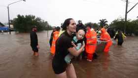 Una mujer sostiene a su bebé durante las inundaciones de Lismore, al norte de Nueva Gales del Sur