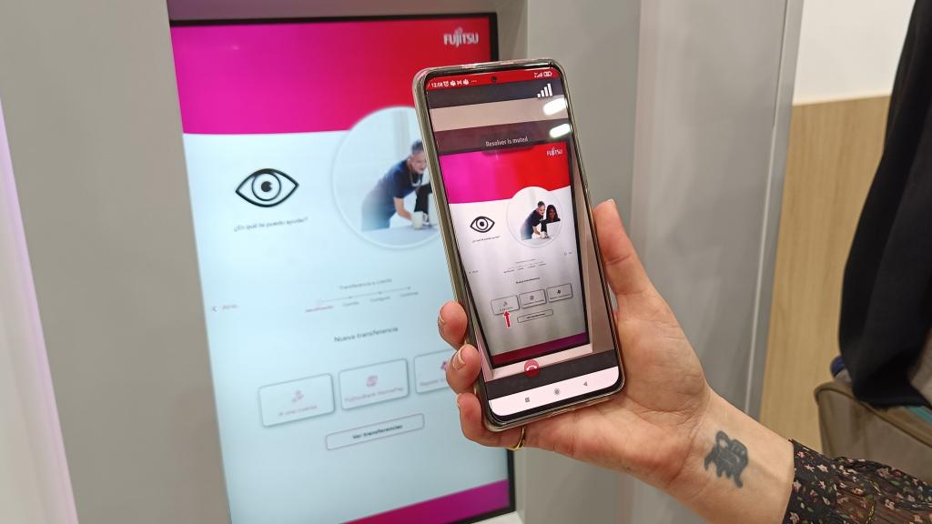 El técnico marca el botón en el móvil ante el cajero de Fujitsu