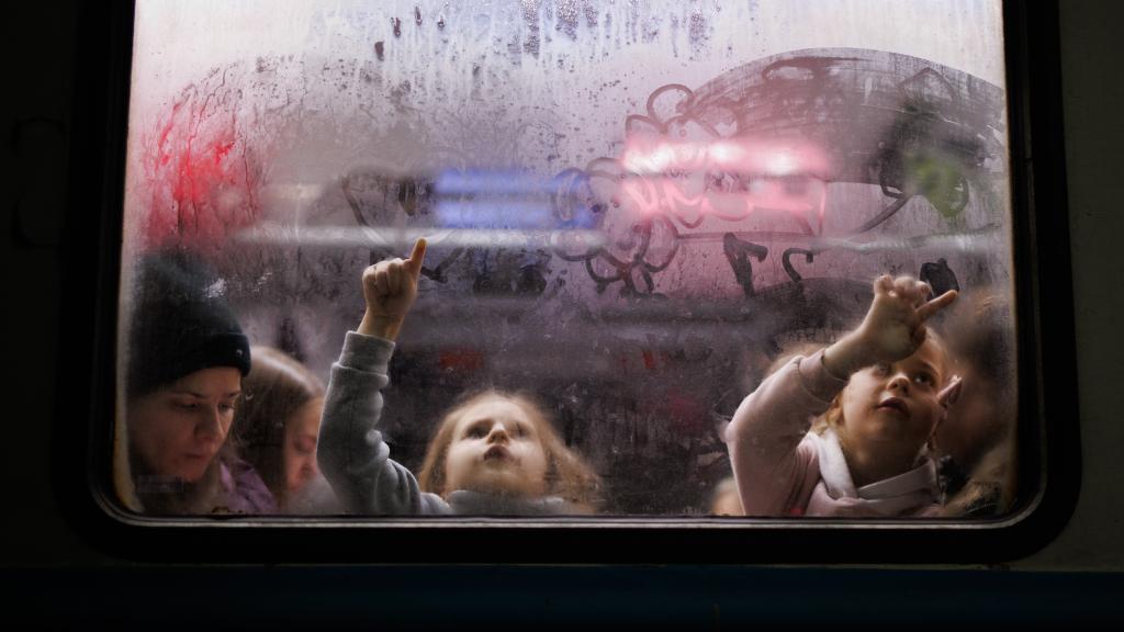 Dos niñas pintan el cristal de un vagón en la estación de tren de Leópolis, en Ucrania.