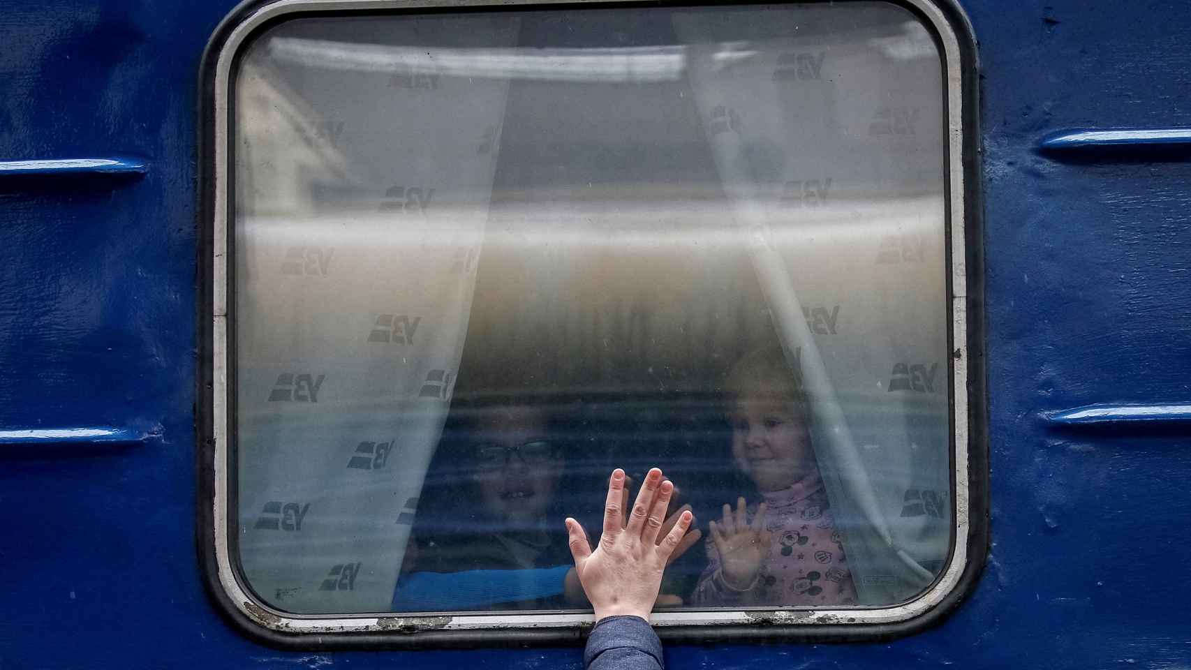 Dos niños observan a su padre desde el tren que pone rumbo a Lviv, oeste de Ucrania, desde Kiev.