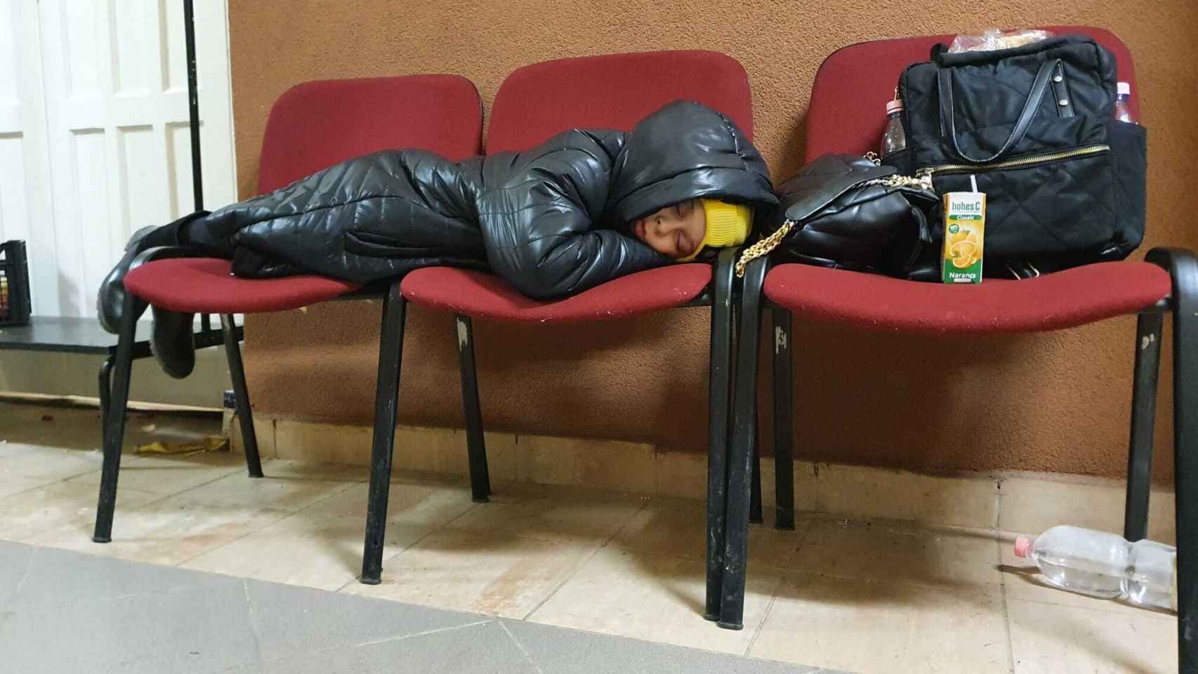 Un niño ucraniano duerme en unas sillas