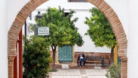 Un señor mayor sentado en un banco de la plaza del pueblo en Genalguacil.