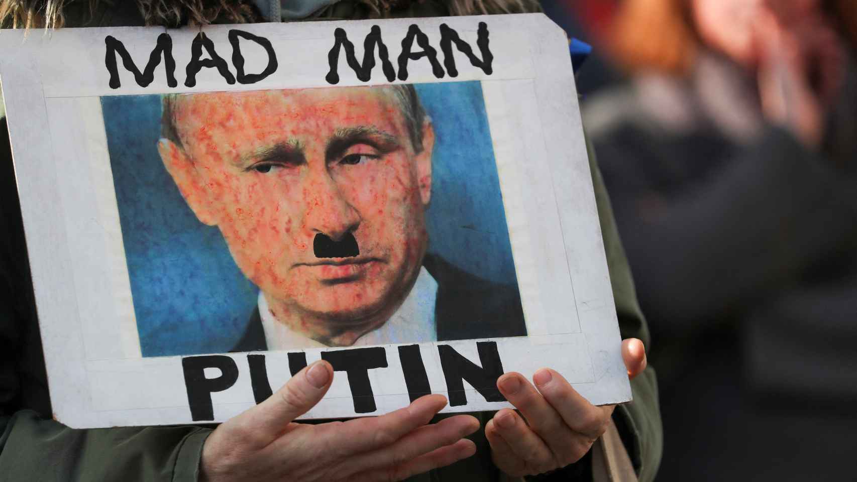 Una persona sostiene un cartel de protesta contra Putin en Edimburgo.