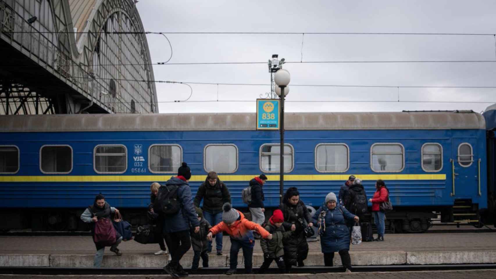 Una familia cruza las vías del andén número uno en Lviv, tras llegar desde el este del país.