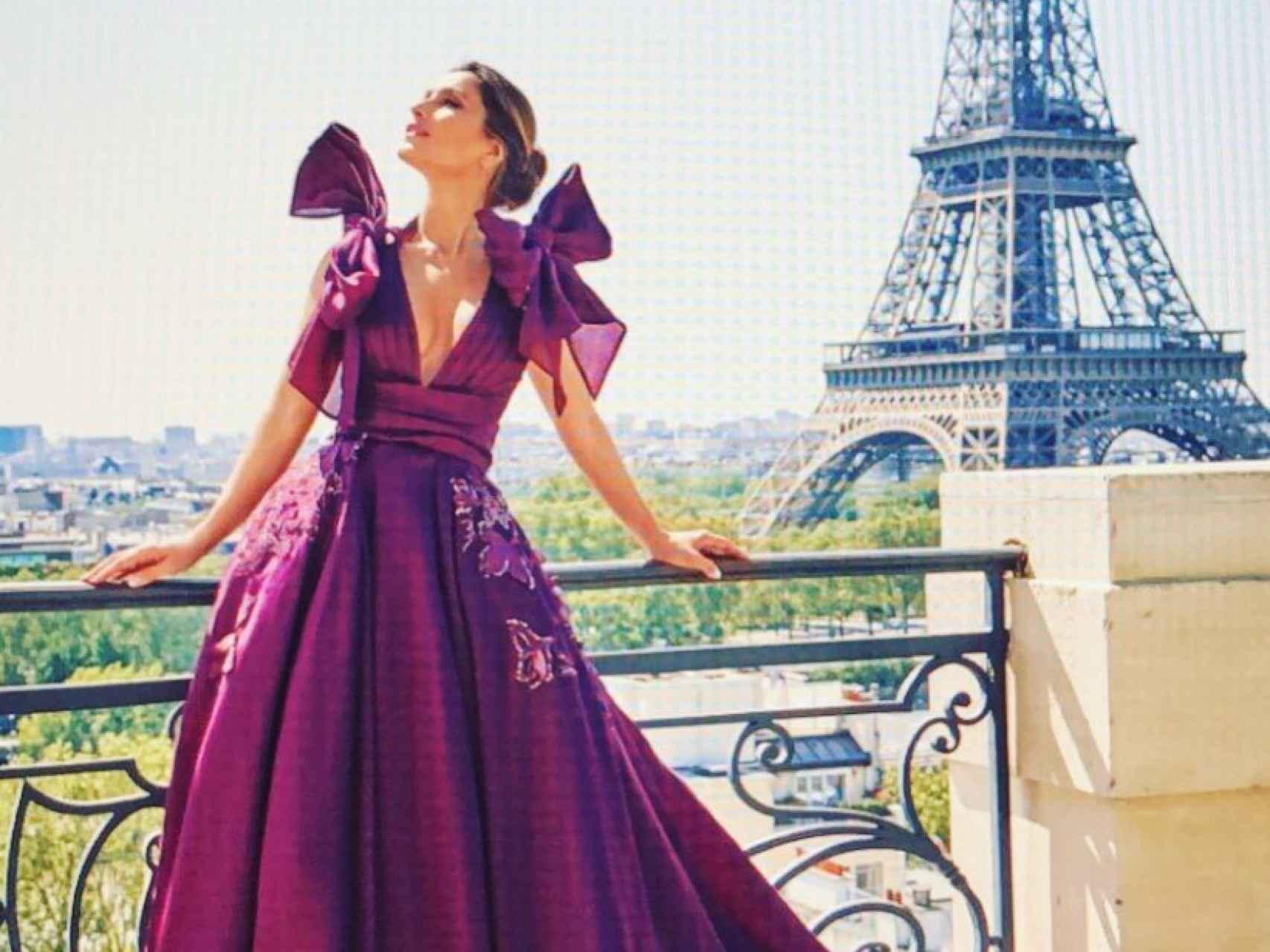 La exmujer de Enrique Ponce posando con uno de sus diseños en París, con la Torre Eiffel de fondo.