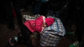 Una niña duerme mientras su familia aguarda al aviso en pantalla del próximo tren. Foto: F.T.