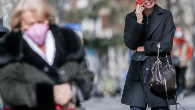 Una mujer habla por teléfono sin mascarilla.