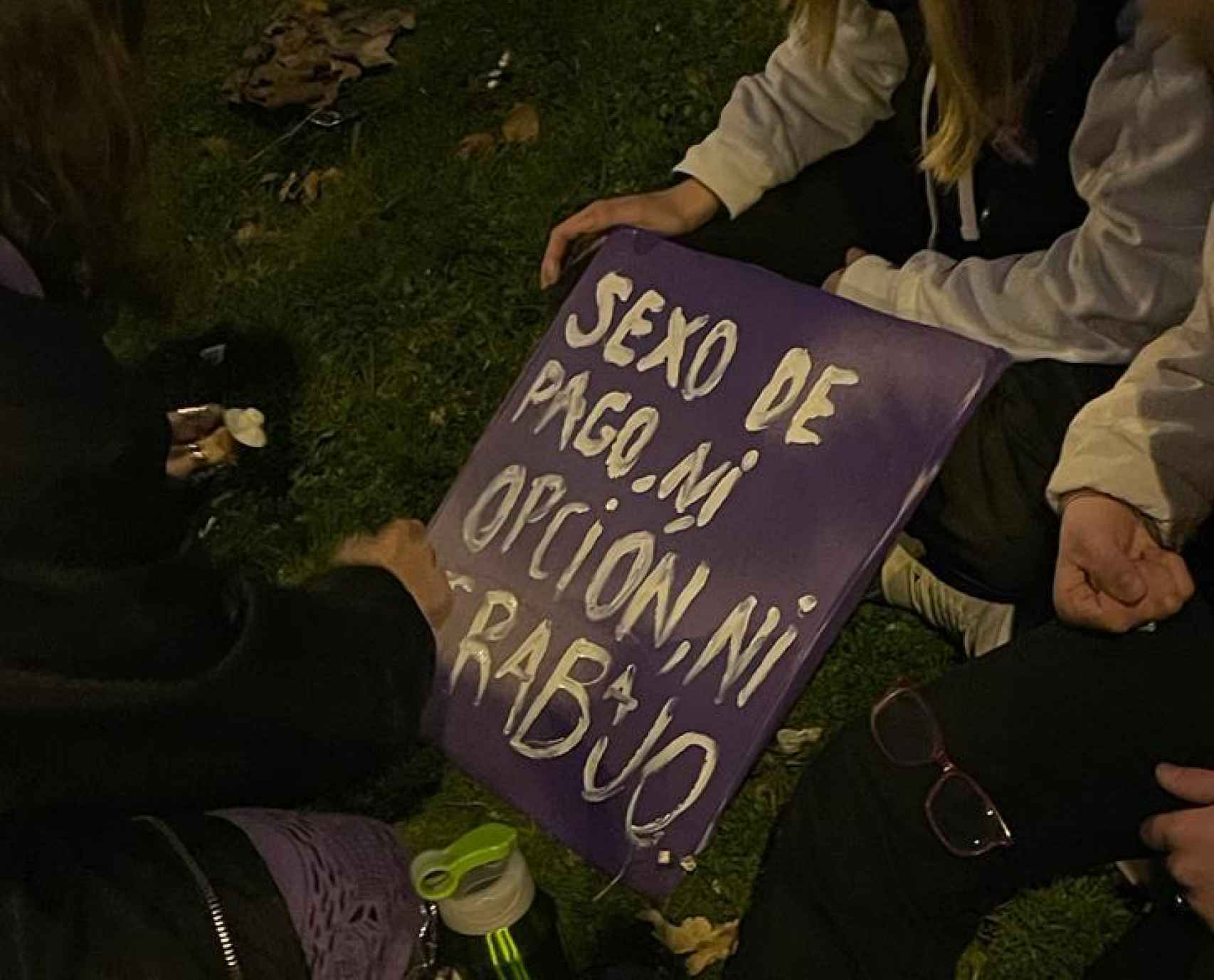 Unos jóvenes pintando un cartel antiprostitución durante el 8-M en Madrid.
