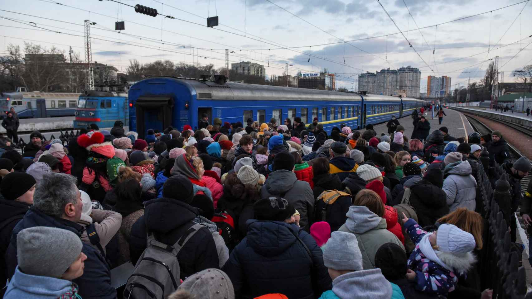 Civiles ucranianos se apelotonan en un andén de Odesa para tomar un tren y huir del país.