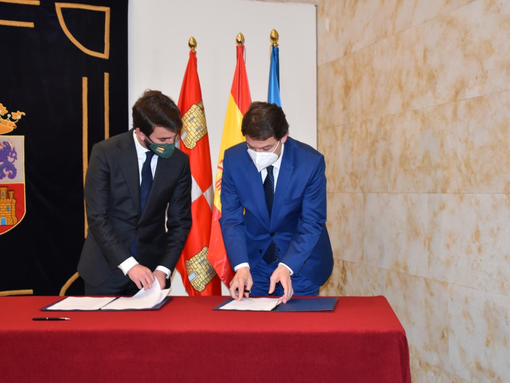 El candidato de Vox, Juan García-Gallardo, observa como el presidente en funciones, Alfonso Fernández Mañueco, rubrica el acuerdo entre PP y Vox el pasado jueves