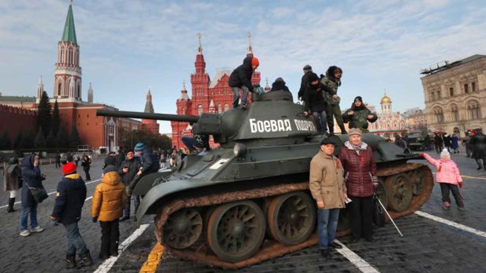 Varios ciudadanos se acercan a un tanque de la era soviética tras el desfile organizado para conmemorar la parada militar celebrada el 7 noviembre de 1941.