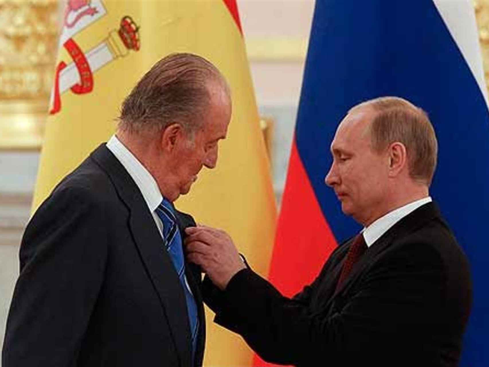 EL presidente ruso, Vladimir Putin, coloca una medalla a Juan Carlos I, con quien mantiene una buena amistad.