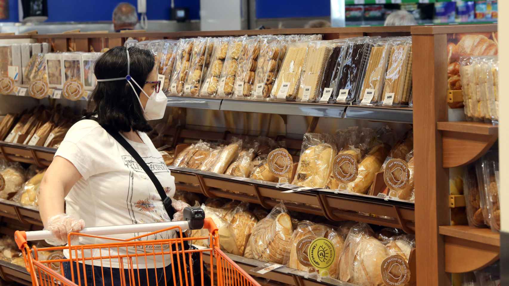 Una mujer mira los precios de distintos productos en un supermercado