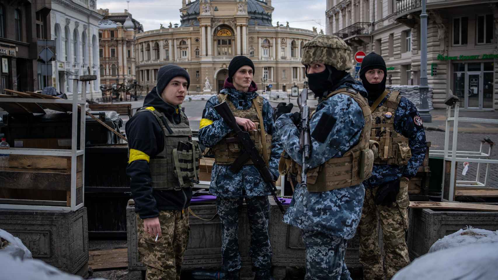 Un grupo de soldados jóvenes comparte tabaco frente a la Ópera de Odesa.