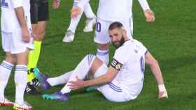 Karim Benzema, sentado sobre el césped se duele de su pierna izquierda
