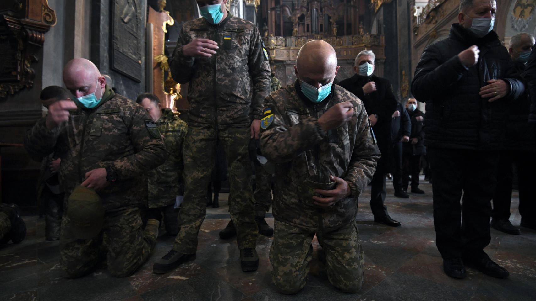 Soldados ucranianos rezan en una iglesia.