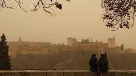 Dos personas observan la Alhambra desde el Mirador de San Nicolás.