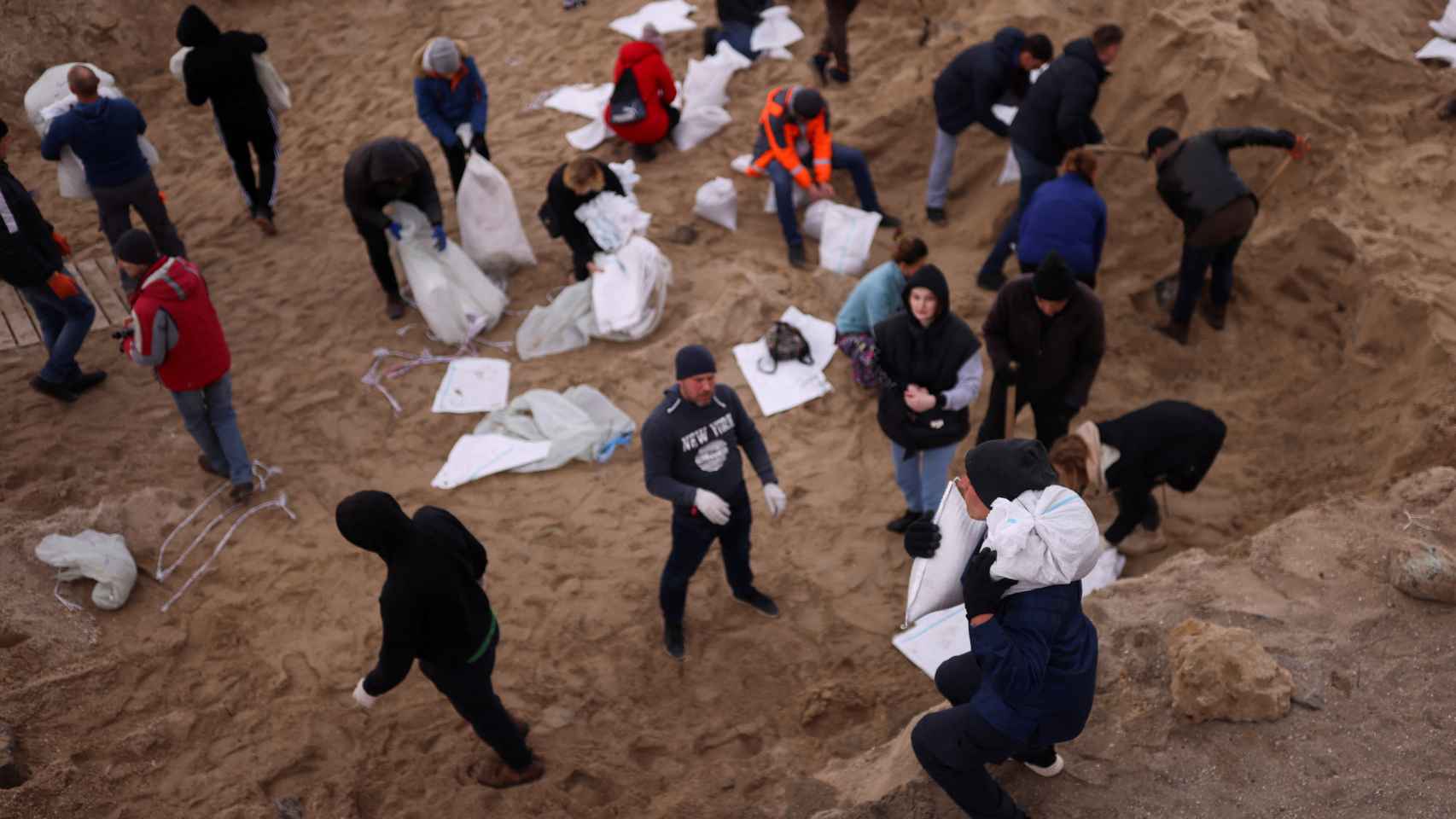 Civiles ucranianos cargan sacos de arena en las playas de Odesa para levantar barricadas.
