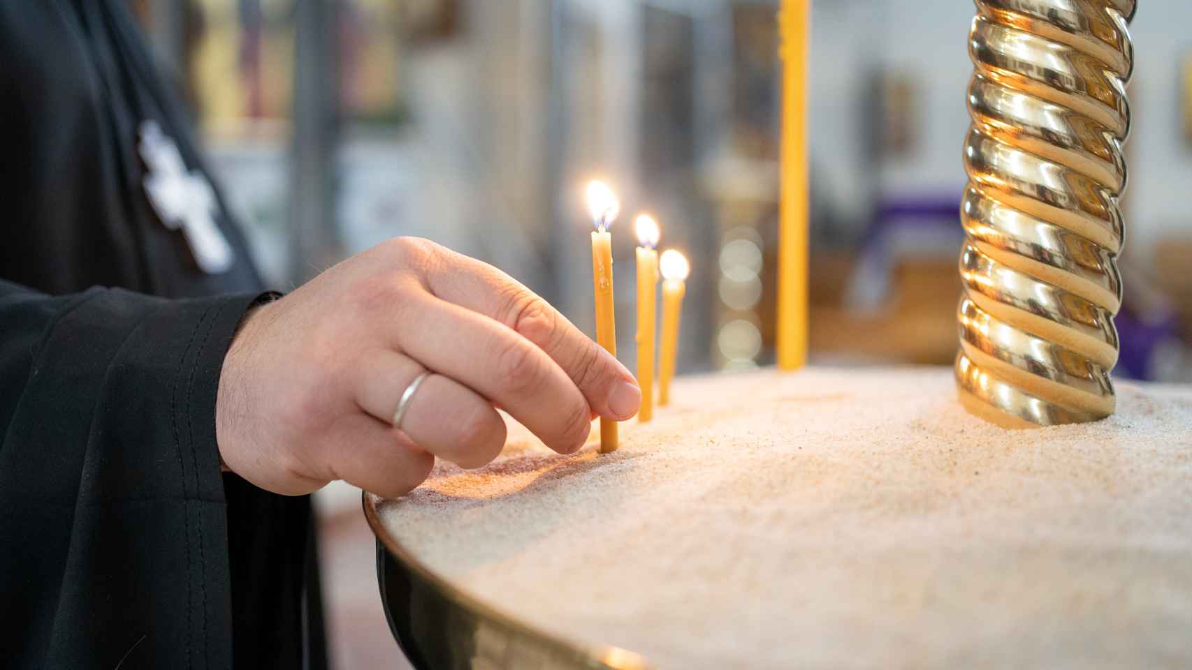El padre Kórdochkin enciende una vela en la catedral ortodoxa rusa de Madrid.