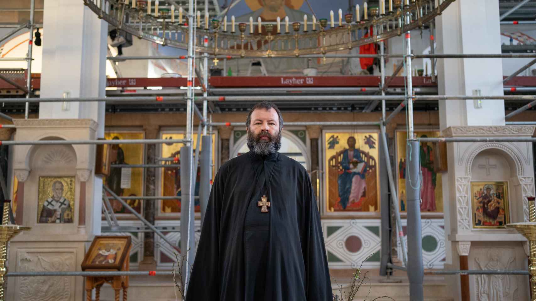 El padre Kórdochkin, con los andamios de fondo en la catedral ortodoxa.