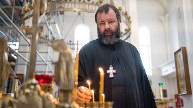 El padre Kórdochkin enciende una vela en el interior de la catedral ortodoxa rusa de Madrid. REPORTAJE GRÁFICO Y VÍDEO DE SARA FERNÁNDEZ