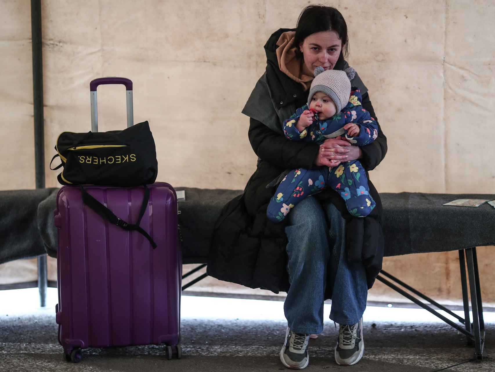 Una madre descansa con su hija mientras espera para cruzar la frontera en Palanca (Moldavia).