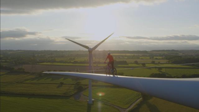 Danny MacAskill montando en bici en la pala de un aerogenerador.