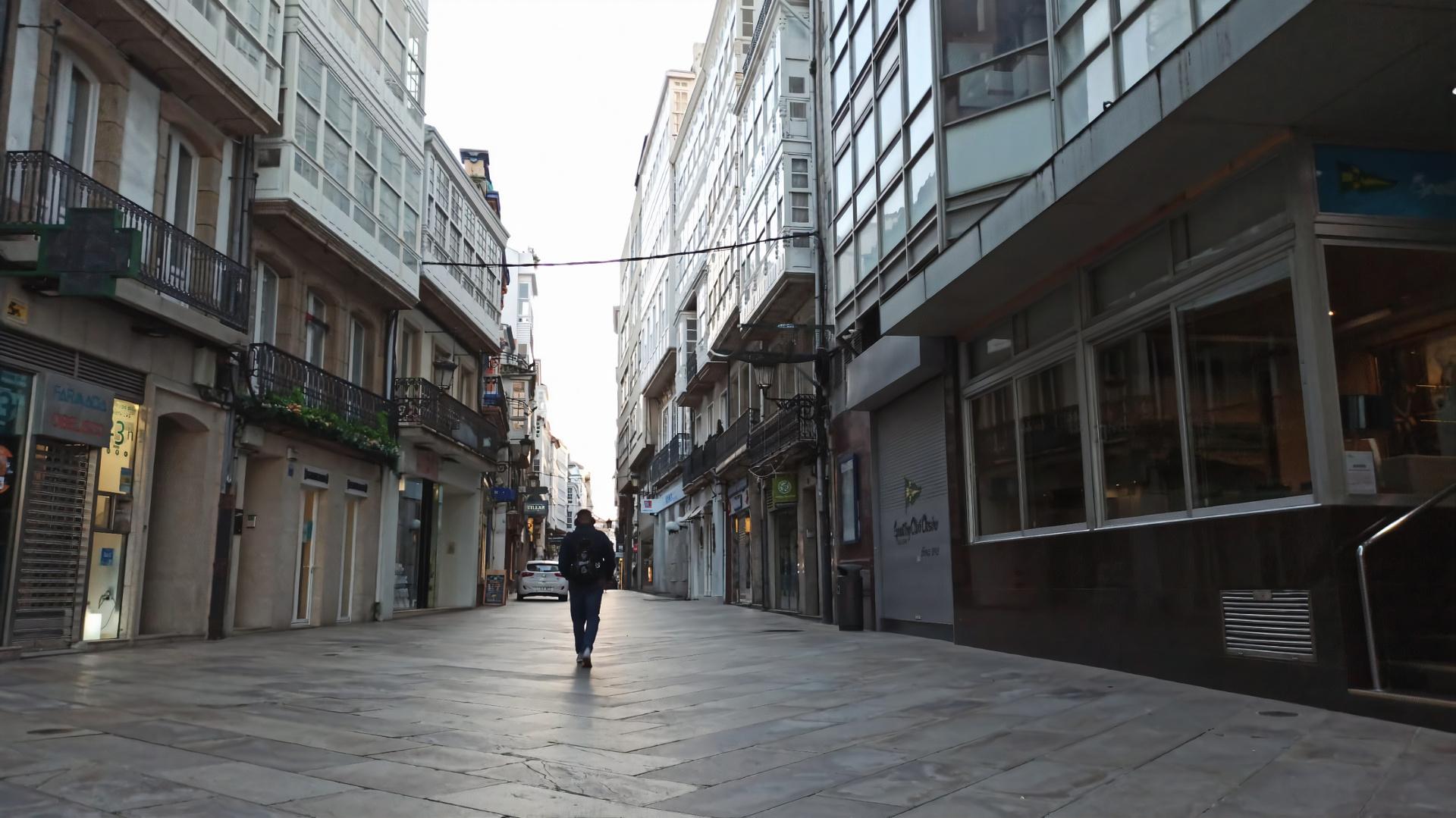 Una persona camina por la Calle Real de A Coruña un día laboral por la mañana.