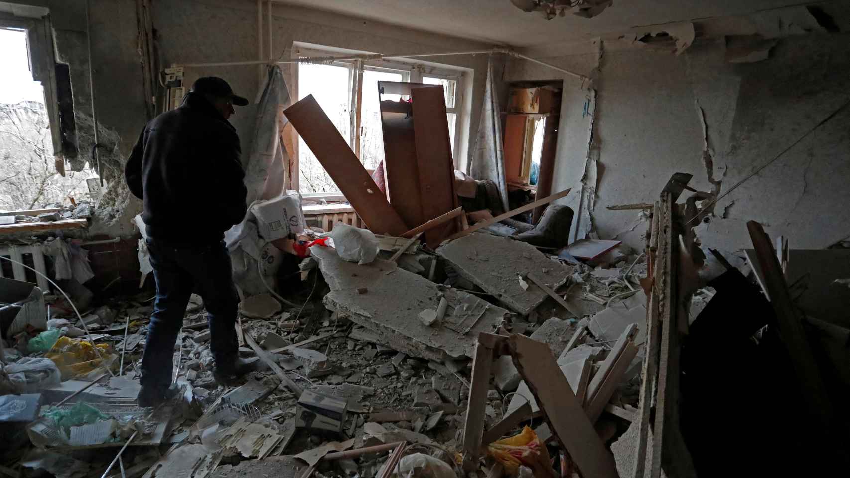 Un residente camina dentro de un apartamento dañado en la ciudad sitiada de Mariúpol.