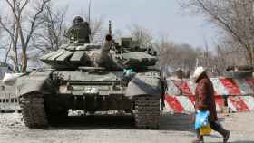 Un residente pasa junto a un tanque de tropas prorrusas en la ciudad sitiada de Mariupol.