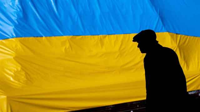 Un hombre camina frente a una bandera ucraniana en Praga, en República Checa.