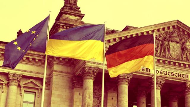 Banceras comunitaria, ucraniana y alemana ondean durante una protesta contra la guerra en Berlín.