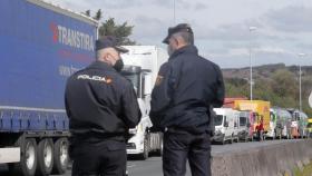 Dos agentes de Policía Nacional observan los camiones parados en el arcén el pasado 14 de marzo en Lugo.